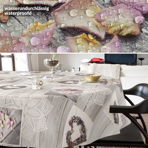 Wasserundurchlässige runde Tischdecke in Holzoptik mit Spitzenmotiven und Lavendelherzen in einem hellen Wohnzimmer.