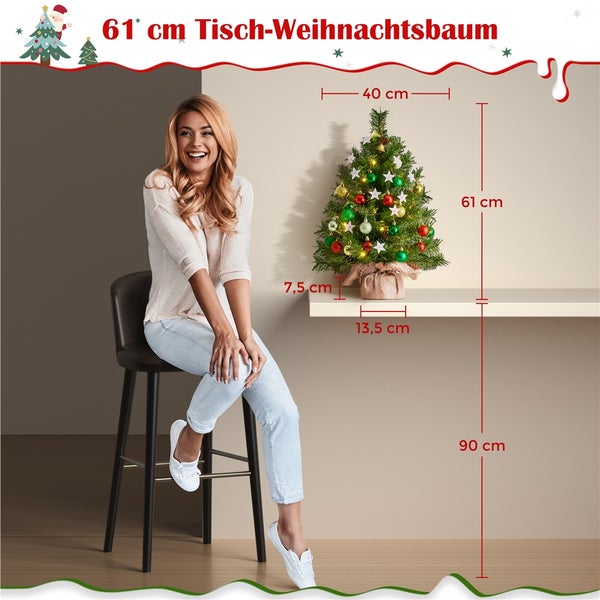 Dekorierter, kleiner Weihnachtsbaum mit LED-Lichtern und Ornamenten auf einem Tisch.