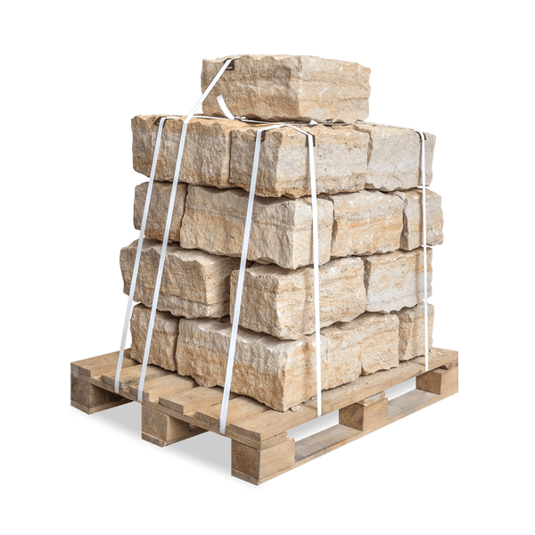 Beige Mauersteine aus Naturstein auf einer Holzpalette, gesichert mit weißen Bändern.
