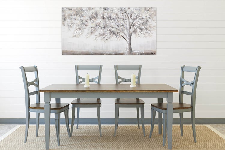 Esstisch mit vier Stühlen und Baum-Wandbild in einem hellen Esszimmer.