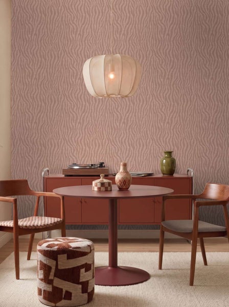 Wohnzimmer mit Vliestapete mit Wellenmuster, runder Tisch, zwei Holzstühle, Sitzhocker und ein Sideboard in einer modernen Einrichtung.