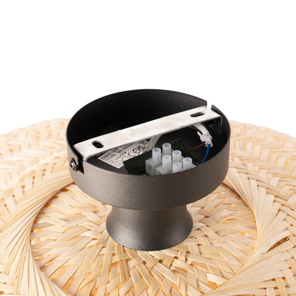 Detailaufnahme der Deckenhalterung einer Lampe mit Rattan-Schirm.