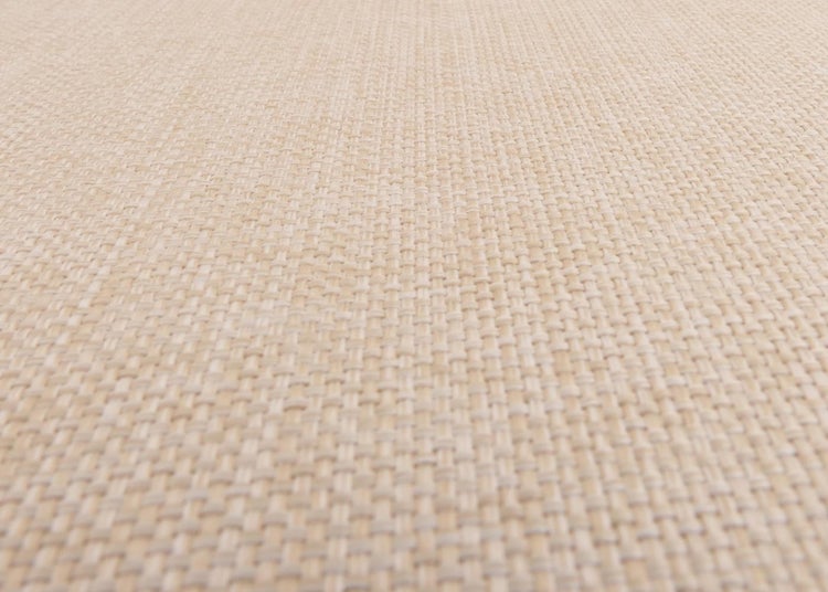 Nahaufnahme der gewebten Struktur eines Teppichs in Beige.