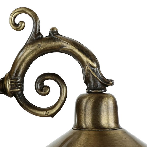 Detail einer bronzefarbenen Lampe mit dekorativem Arm