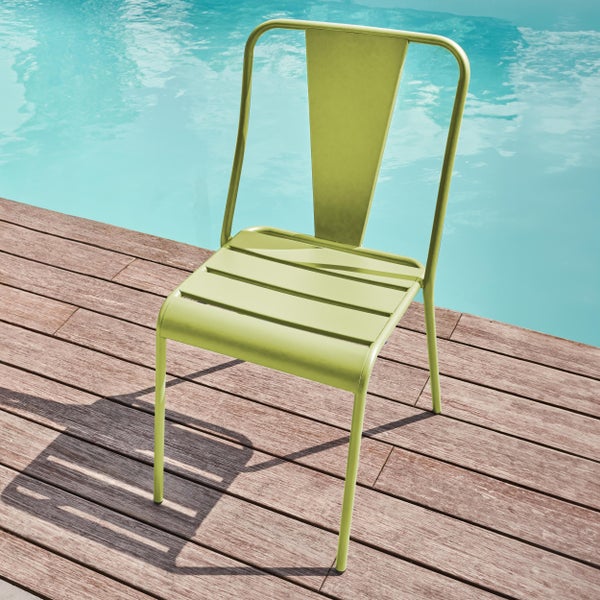Hellgrüner Gartenstuhl aus Metall auf einer Holzterrasse neben einem Pool.