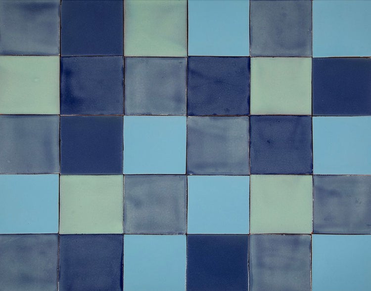 Graue Tasse auf blau gemusterten Fliesen