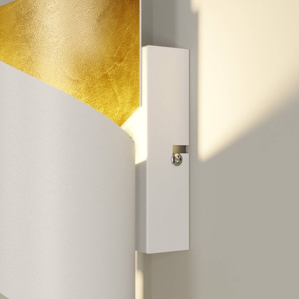 Nahaufnahme einer Wandleuchte mit weißer, strukturierter Oberfläche, goldfarbenem Innendetail und sichtbarer Montagehalterung.