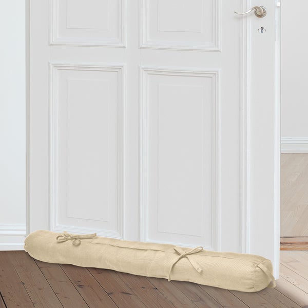 Zugluftstopper vor einer Tür auf einem Holzboden