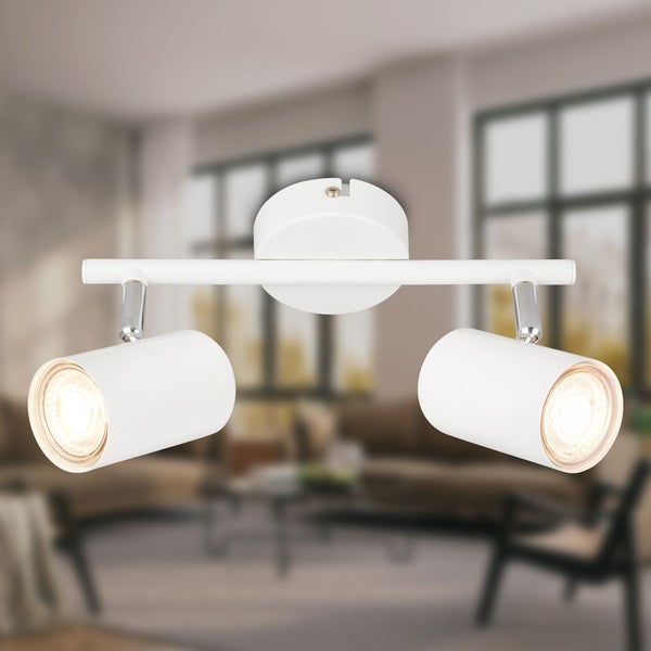 Moderner Deckenstrahler in Weiß mit zwei verstellbaren Spots in einem hellen Wohnzimmer.