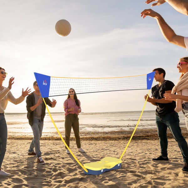 Tragbares Volleyballnetz mit Standfuß, Gruppe spielt Volleyball am Strand bei sonnigem Wetter.