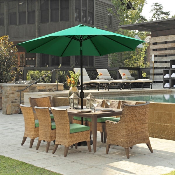 Gartenszene mit Esstisch, Stühlen, Sonnenschirm und Liegestühlen am Pool