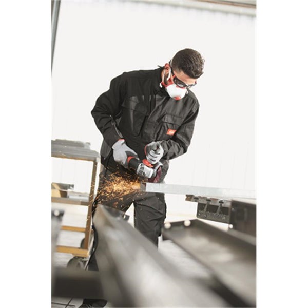 Handwerker mit Schutzausrüstung trennt ein Metallprofil mit einem Winkelschleifer in einer Werkstatt.