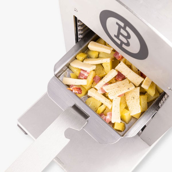 Nahaufnahme eines Beefer Grills mit einer Grillschale gefüllt mit Kartoffeln, Speck und Käse. Beefer Logo auf der Oberseite.