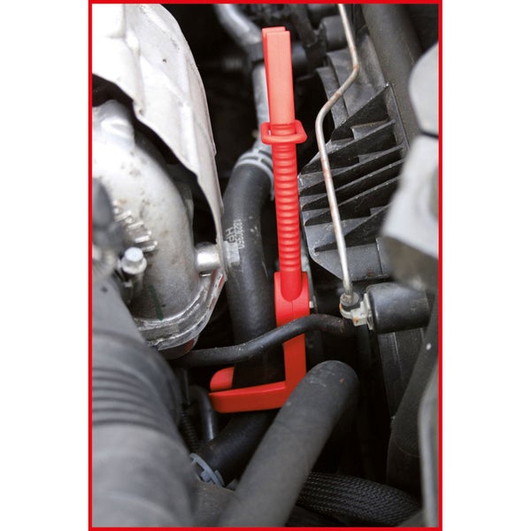 Rote Schlauch-Abklemmzange aus Kunststoff klemmt einen schwarzen Schlauch im Motorraum eines Autos ab.