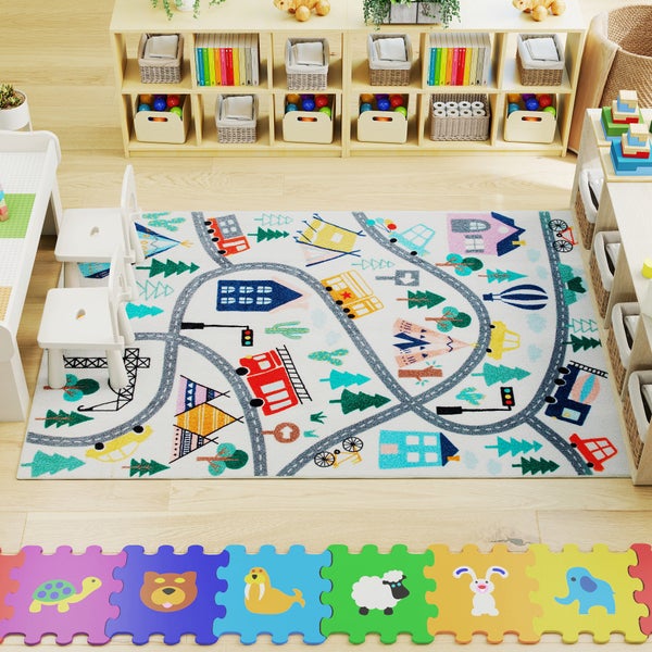 Helles Kinderzimmer mit Straßen-Spielteppich, weißen Kindermöbeln, hölzernen Spielzeugregalen und einer bunten Puzzlematte auf hellem Holzboden.