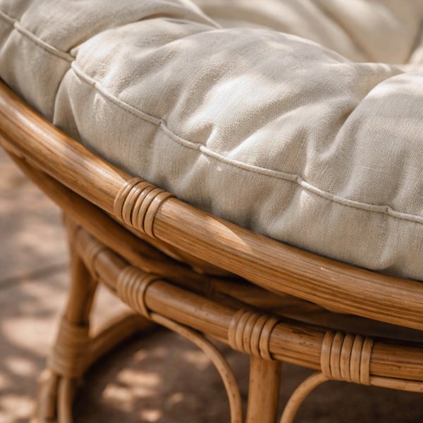 Papasansessel mit braunem Metallgestell und hellem Polster in der Rückansicht.