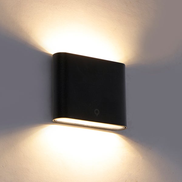 Schwarze LED-Wandleuchte aus Metall mit Up-and-Down-Lichteffekt an einer Wand montiert.