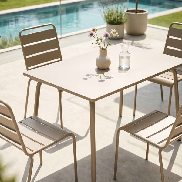 Modernes Gartenmöbel-Set aus Metall mit rechteckigem Tisch und vier Stühlen auf einer hellen Terrasse neben einem Pool.