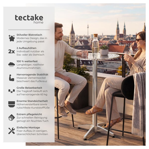 Ein Paar sitzt an einem höhenverstellbaren Tectake Bistrotisch aus Aluminium auf einer Dachterrasse mit Blick über eine Stadt bei Sonnenuntergang.
