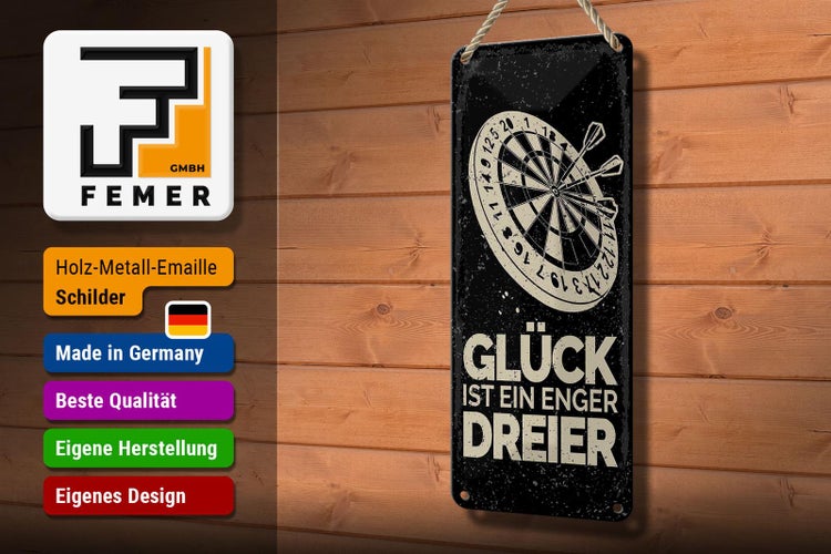 Dekoratives Metallschild mit Darts-Motiv und dem Schriftzug Glück ist ein enger Dreier neben Topfpflanze und Stifthalter