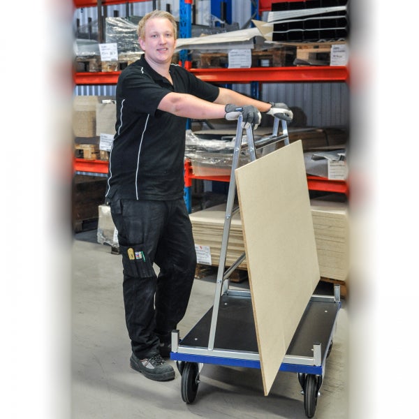 Mitarbeiter mit Plattentransportwagen im Lager