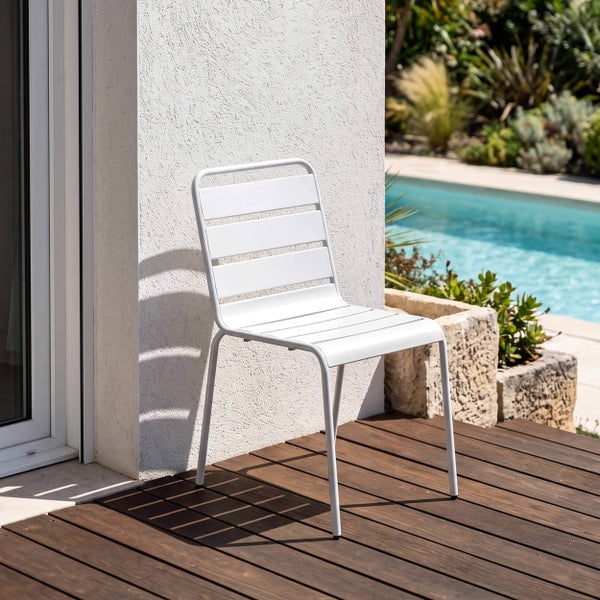 Moderner Gartenstuhl aus Metall mit Querstreben auf einer Holzterrasse neben einem Swimmingpool und einer Hauswand.