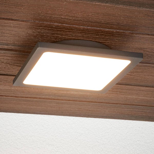 Quadratische LED-Deckenleuchte mit anthrazitfarbenem Gehäuse montiert auf einer Holzoberfläche.