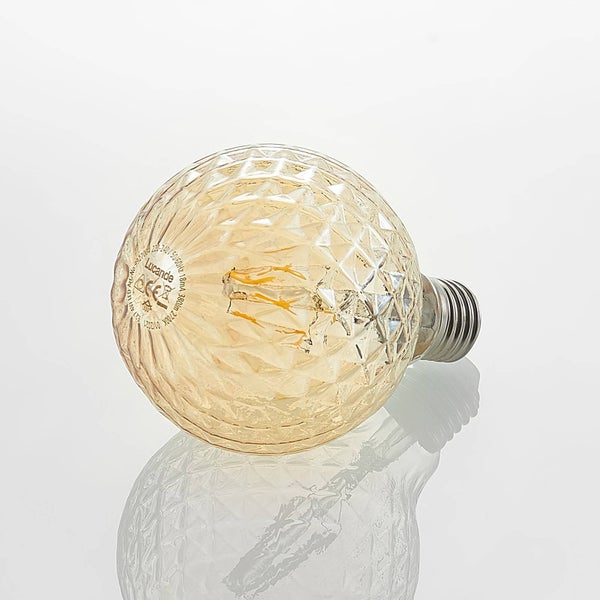 Dekorative LED-Glühbirne von Lucande mit E27-Gewinde und bernsteinfarbenem Glas mit Diamantstruktur.
