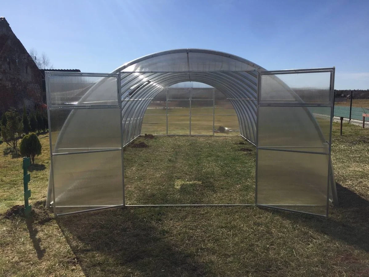 Tunnel Gewächshaus mit geöffneten Türen auf einer Rasenfläche