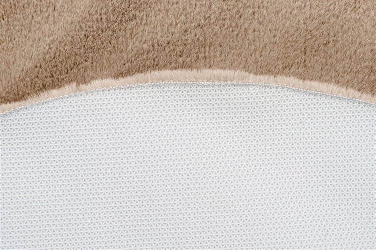 Detailansicht eines Kunstfell-Teppichs mit weichem Flor und rutschfester Unterseite mit geometrischem Muster.