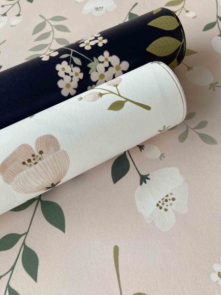 Zwei Rollen Vliestapete mit floralem Muster aus Blumen und Blättern in verschiedenen Designs.
