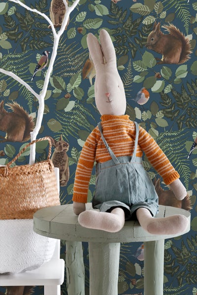 Dekorative Szene mit Plüschhase, Korbtasche und einem Wandbild mit Waldmotiven