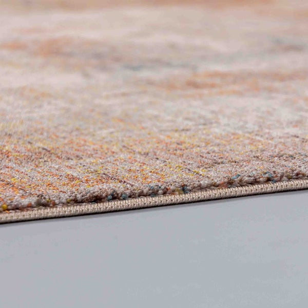 Nahaufnahme eines Kurzflorteppichs mit abstraktem Muster und geketteltem Rand.