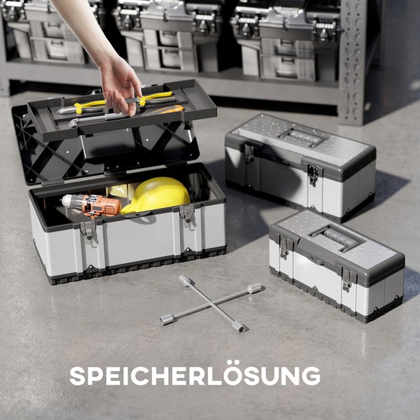 Stapel von drei Werkzeugkisten auf dem Boden vor einem Regal