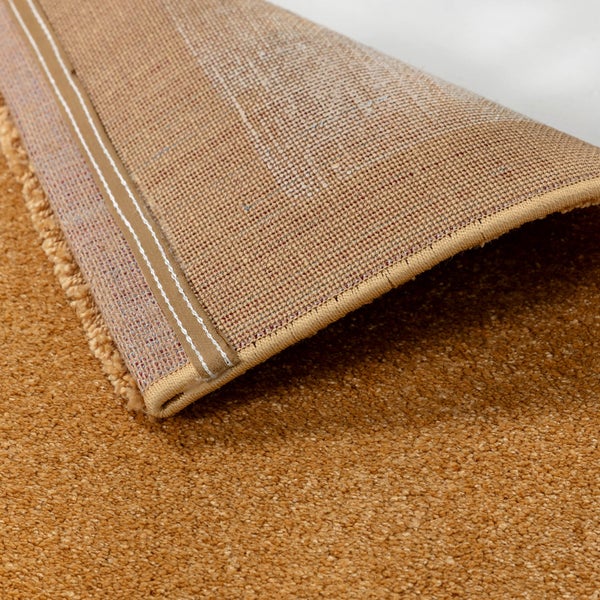 Detailansicht eines Teppichs mit dichtem Flor, Textilrücken und umkettelter Kante mit Naht.