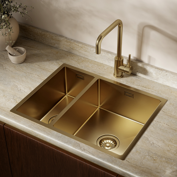 Doppelspülbecken aus Edelstahl in der Farbe Gold mit passender Küchenarmatur eingebaut in einer Naturstein Arbeitsplatte.