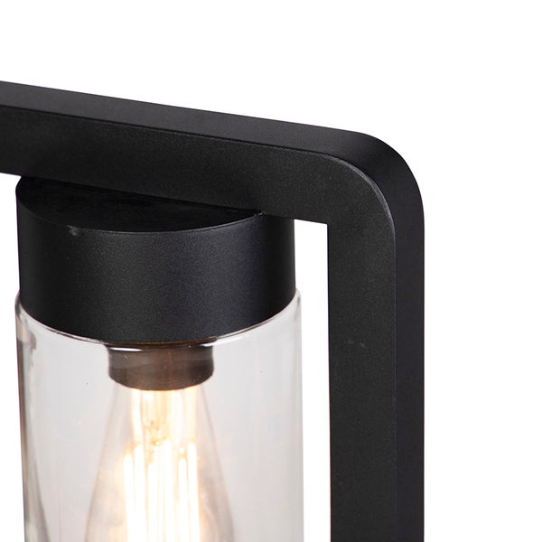 Detailansicht einer modernen Außenleuchte mit schwarzem Metallrahmen, klarem Glaszylinder und eingeschaltetem Filament-Leuchtmittel.