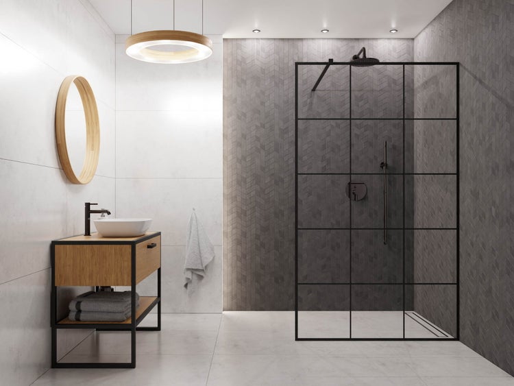 Modernes Badezimmer mit Holz-Waschtisch, rundem Spiegel und begehbarer Dusche mit schwarzer Raster-Glaswand sowie grauen gemusterten Fliesen.