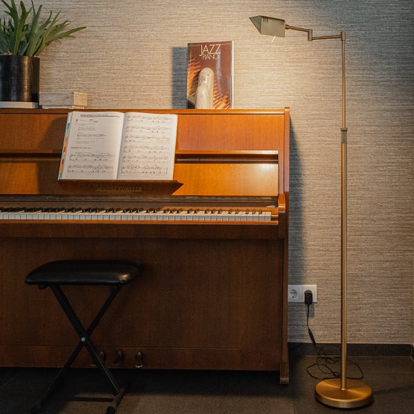 Szene mit Klavier, Noten, Stehlampe und Hocker