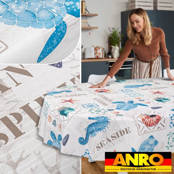 Ovale Wachstuchtischdecke mit maritimem Muster aus Schildkröten, Seepferdchen und Muscheln in einer Küche. ANRO Logo.