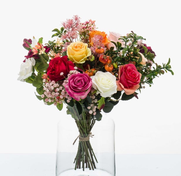 Künstlicher Rosenstrauß in einer Glasvase, bunte Blüten mit grünen Blättern und dekorativen Beeren, mit Kordel zusammengebunden.