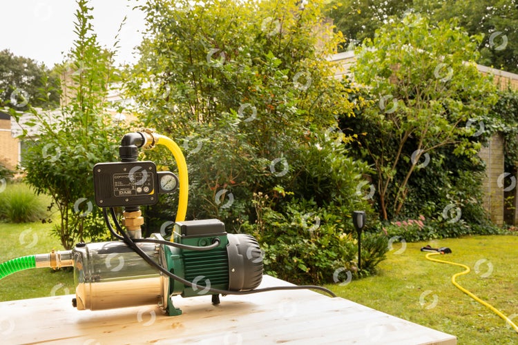 Hauswasserwerk im Garten auf einem Holztisch