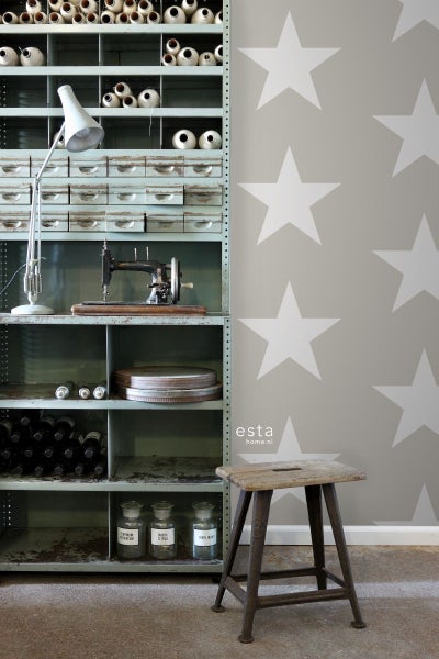 Regal mit Nähmaschine, Lampe und Aufbewahrungsboxen sowie Hocker vor einer Wand mit Sternenmuster.