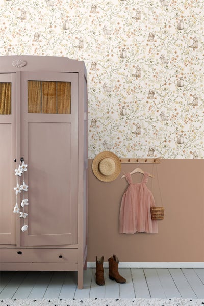 Kinderzimmer mit gemusterter Tapete, Kleiderschrank, Kleidung und Accessoires für Kinder.