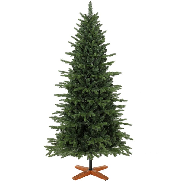 Familie mit Kind und Hund vor einem künstlichen Weihnachtsbaum in einem gemütlich eingerichteten Wohnzimmer mit Kamin.