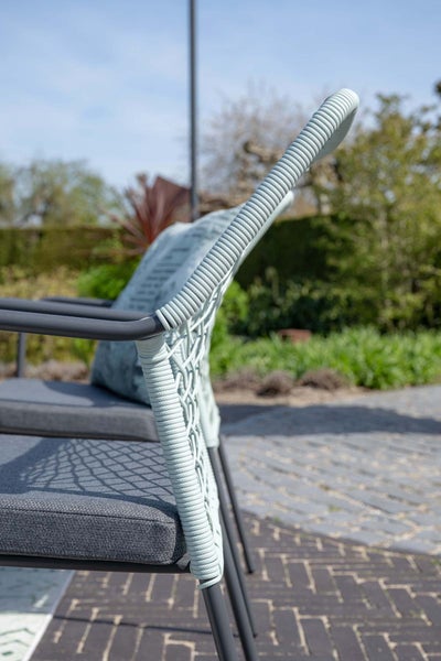 Nahaufnahme eines Gartenstuhls mit Seilbespannung an der Rückenlehne und grauem Sitzpolster im Außenbereich.