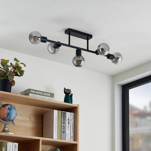 Schwarze Deckenleuchte mit fünf Glaskugeln in einem hellen Raum.