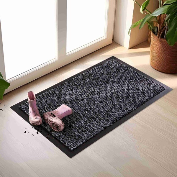 Schmutzfangmatte mit Gummirand, daneben ein Paar Gummistiefel