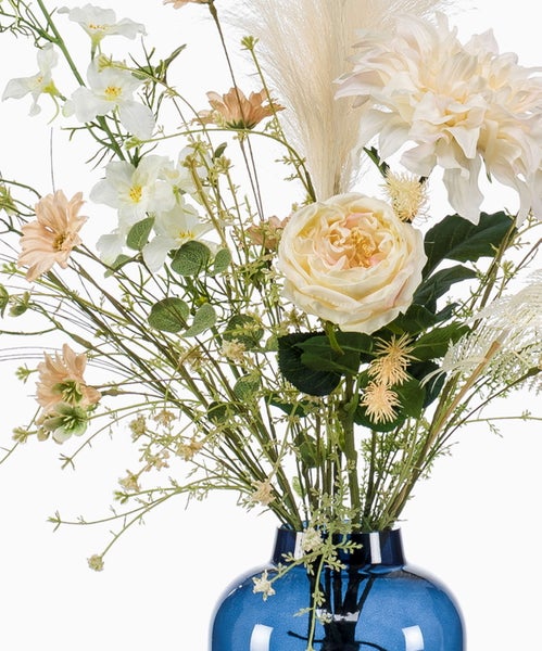 Künstlicher Blumenstrauß mit Rosen, Dahlien und Pampasgras in einer blauen Glasvase