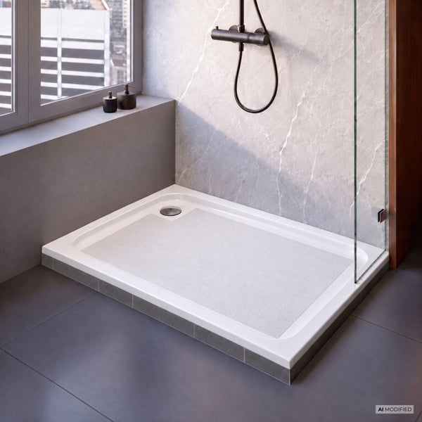 Moderne bodengleiche Duschwanne mit rutschfester Oberfläche und Duscharmatur in einem gefliesten Badezimmer mit Glasduschwand.